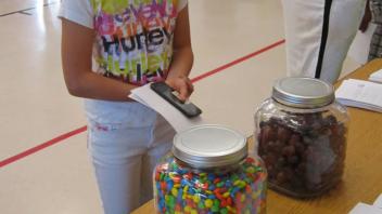 Children counting candy in a jar.