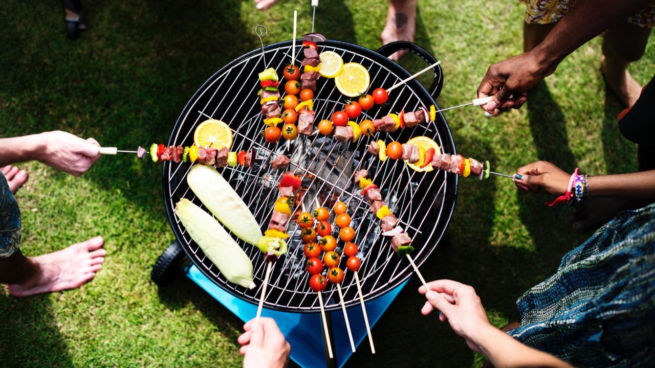 people grilling around a barbecue 