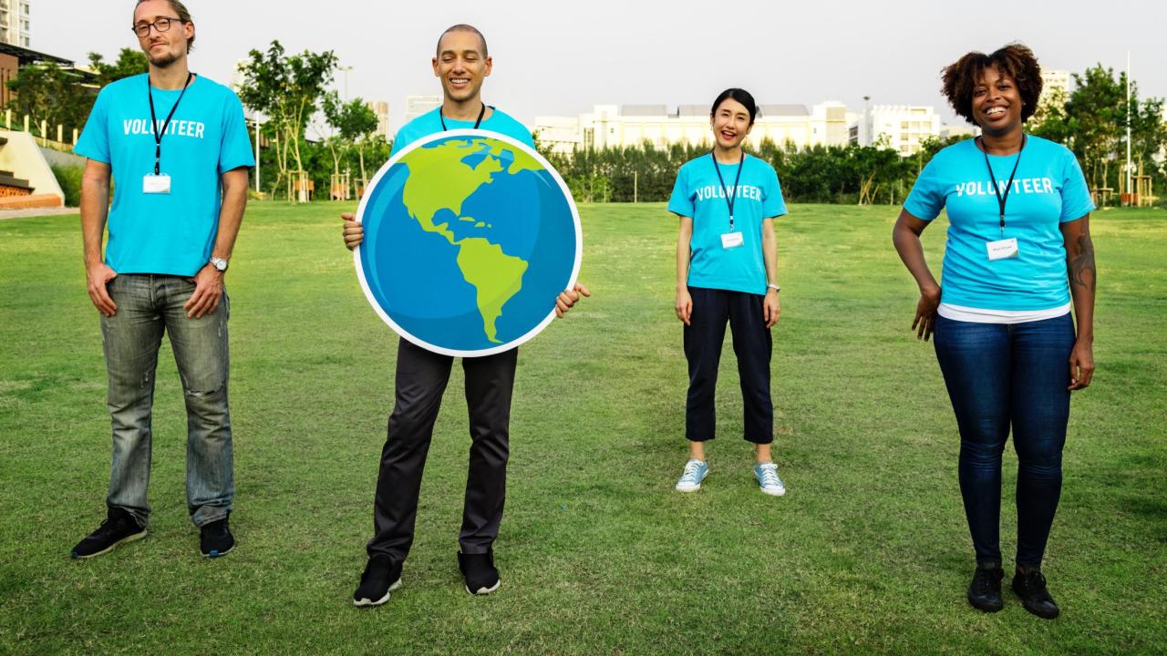 volunteers holding up an Earth poster