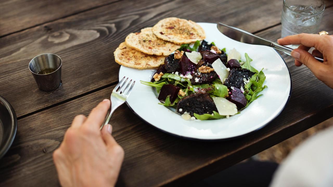 a person eating a salad at a restaurant
