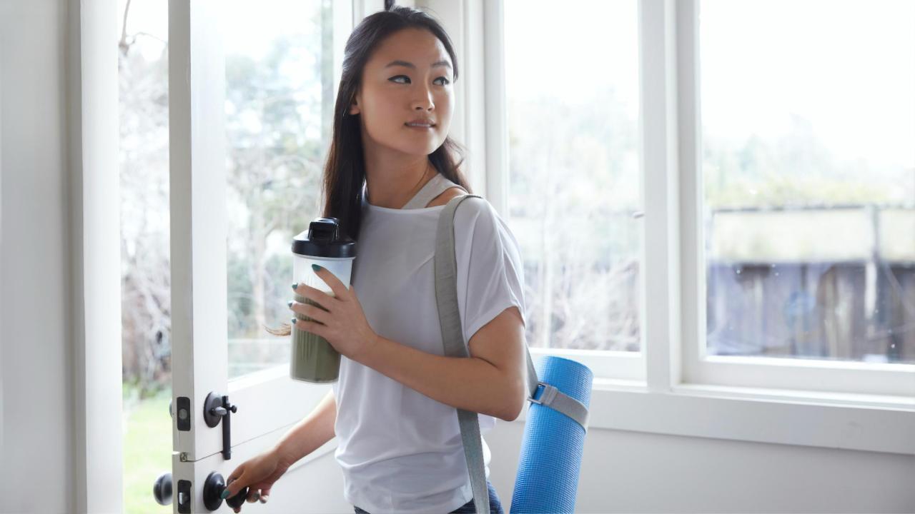 woman with yoga mat and health drink