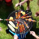 people grilling around a barbecue 